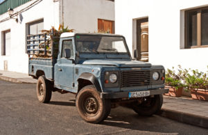 Coches antiguos de Gran Canaria III Land Rover z trzciną cukrową w górskiej miejscowości.